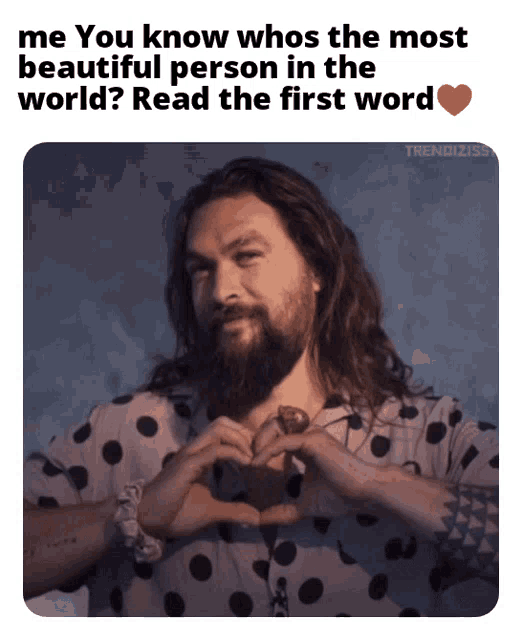 a man with long hair and a beard making a heart shape with his hands