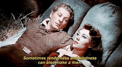 a man and a woman are laying next to each other with the words sometimes tenderness and kindness