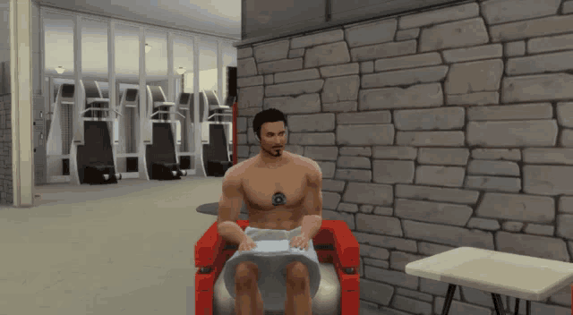 a shirtless man is sitting in a red chair with a towel around his neck