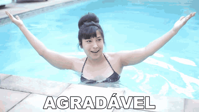 a woman in a bikini is swimming in a pool with the word agradável written on the bottom