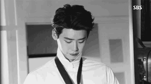 a black and white photo of a man wearing a white shirt and a black tie .