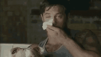 a man is shaving his face with a razor and a napkin .