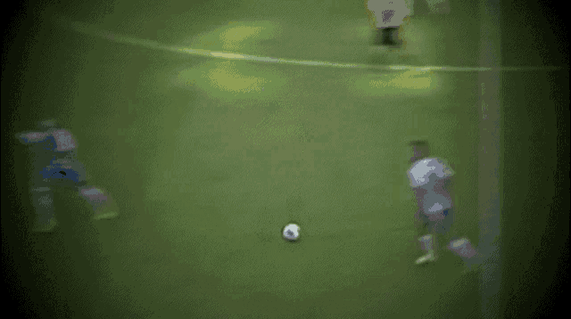 a blurry picture of a soccer game with a referee wearing a pink jersey