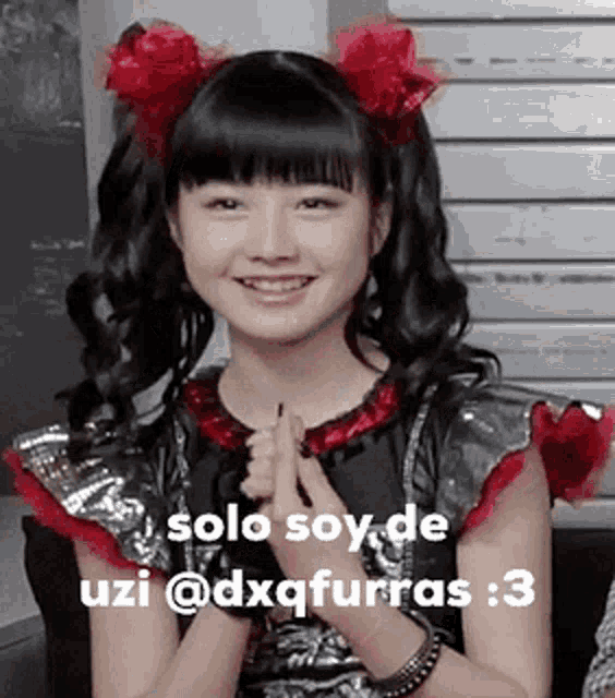 a girl with two red flowers in her hair and the words solo soy de uzi @dxqfurras 3
