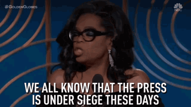 a woman speaking into a microphone with the words " we all know that the press is under siege these days "