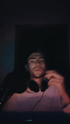a man is wearing headphones and a green light is behind him