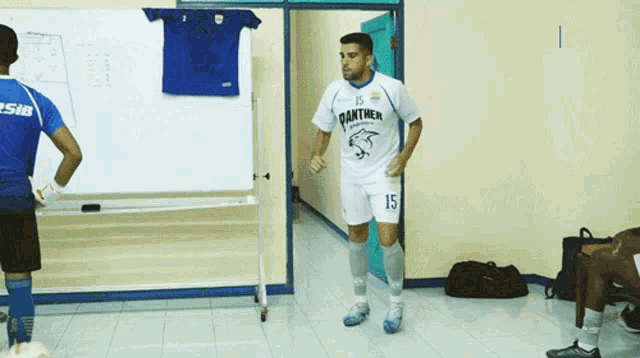 a man wearing a panther jersey is standing in a hallway