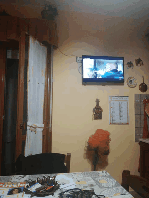 a flat screen tv is hanging on a wall above a calendar