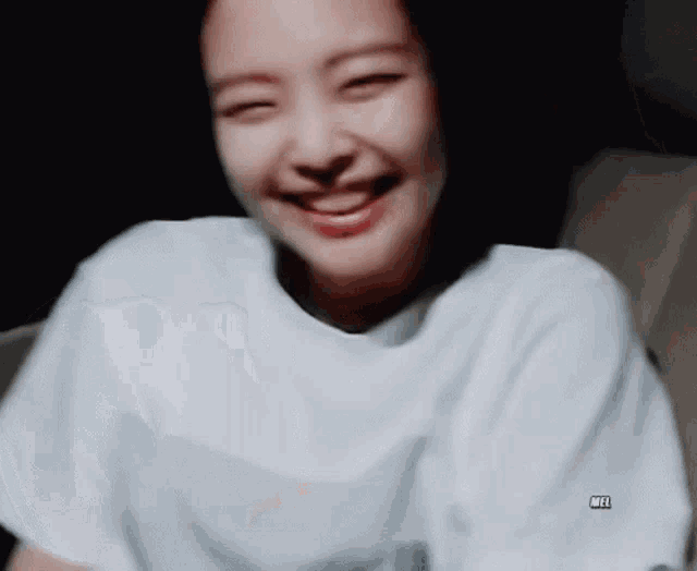 a close up of a woman wearing a white t-shirt smiling .