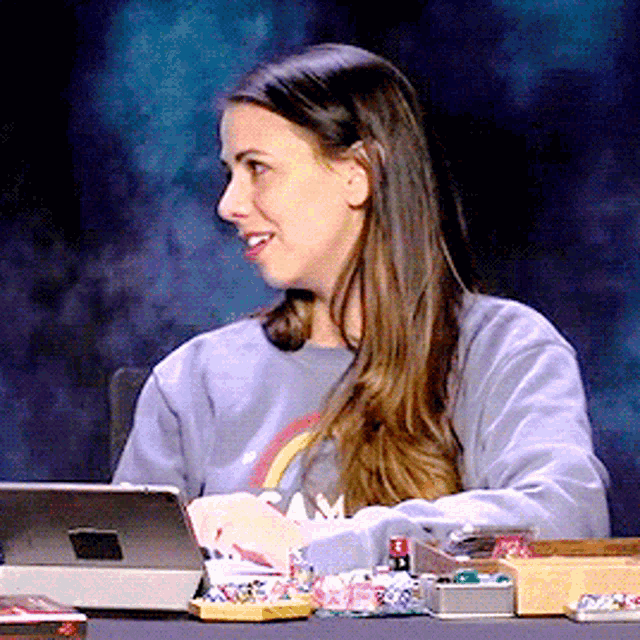 a woman sitting at a desk with a tablet and a box of buttons