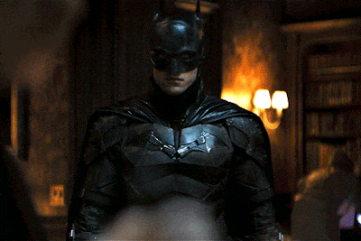 a man in a batman costume is standing in a room