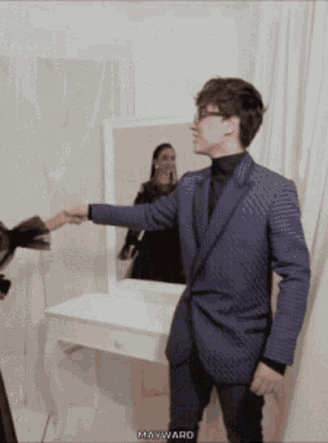 a man in a suit shakes hands with another man