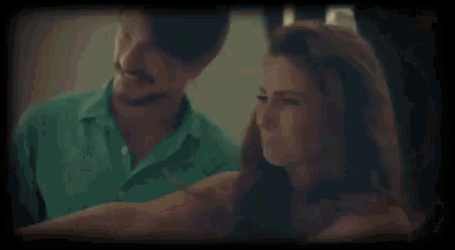 a man and a woman are looking at each other .