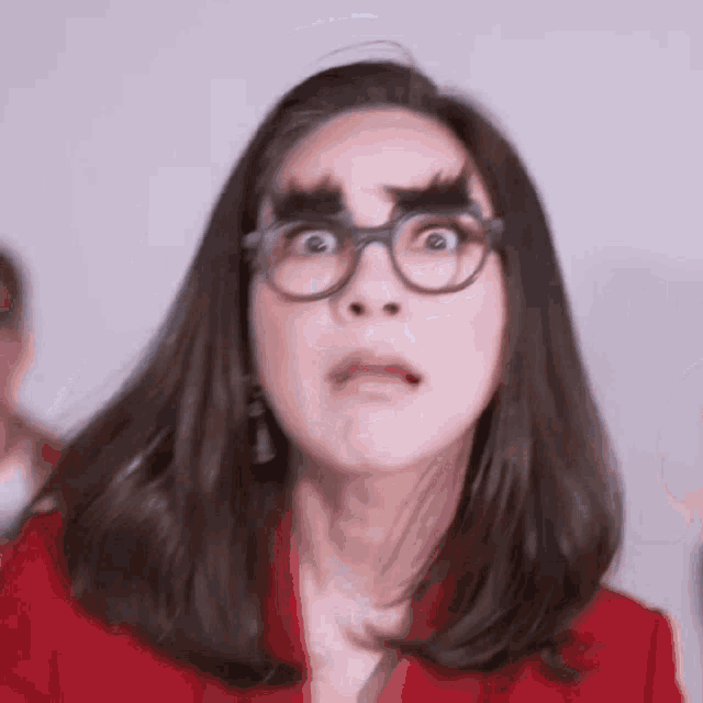 a woman wearing glasses and fake eyebrows is making a surprised face