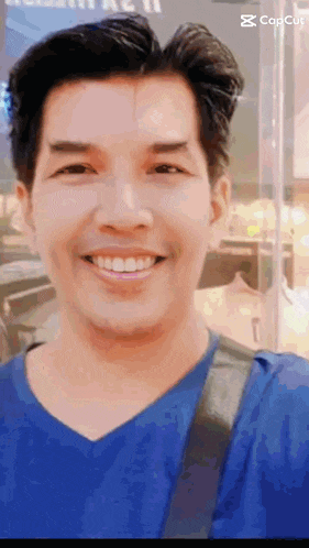 a man in a blue shirt is smiling in front of a sign that says copcut
