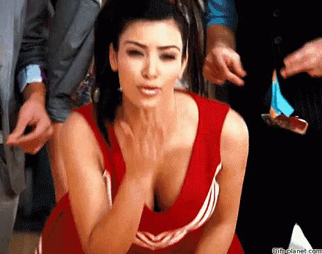 a woman in a red cheerleader uniform is blowing a kiss .