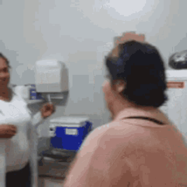 two women are standing in a room talking to each other
