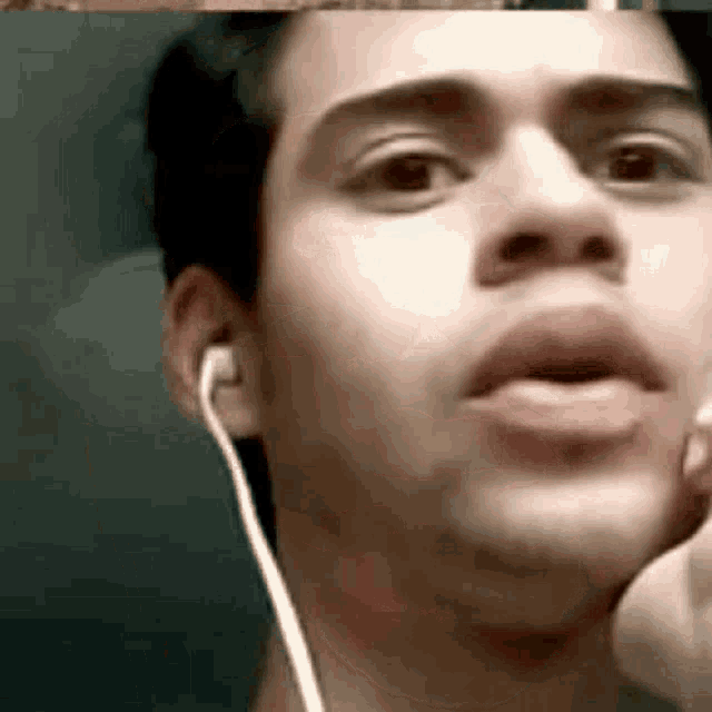 a close up of a man wearing ear buds .
