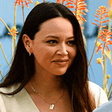 a woman wearing a necklace with a pendant that says ' i love you ' on it
