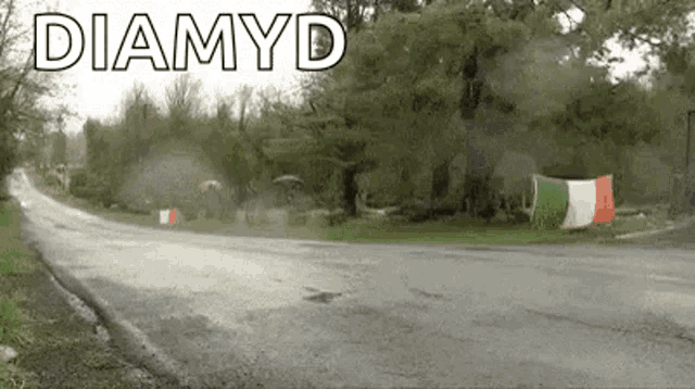 a car is driving down a road with a flag on the side of it .