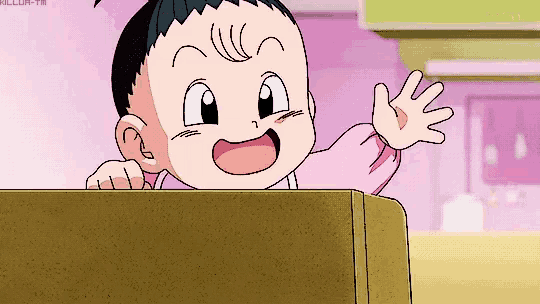 a baby in a pink shirt is waving his hand