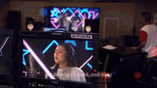a magic monitor shows a woman singing in front of a microphone