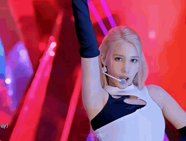 a woman with blonde hair is wearing a microphone and gloves on a stage .