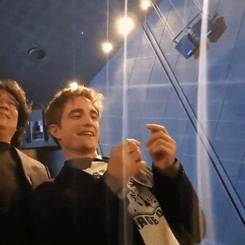 a man wearing a shirt that says ' harry potter ' on it is smiling