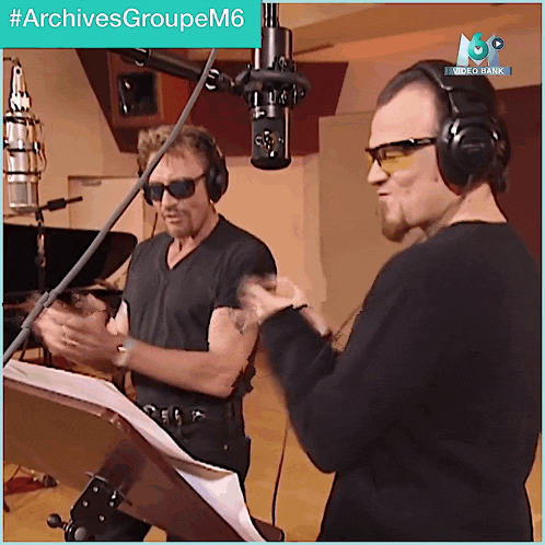 two men wearing headphones and sunglasses are standing in front of a microphone with the hashtag #archivesgroupem6 above them