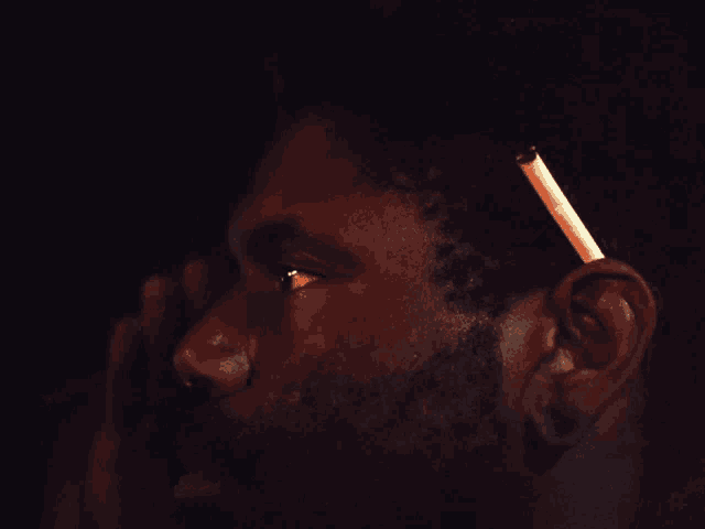 a man with a beard is standing in the dark