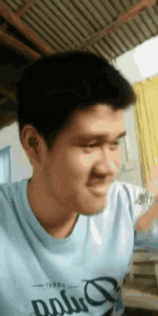a man is making a funny face while wearing a blue shirt .