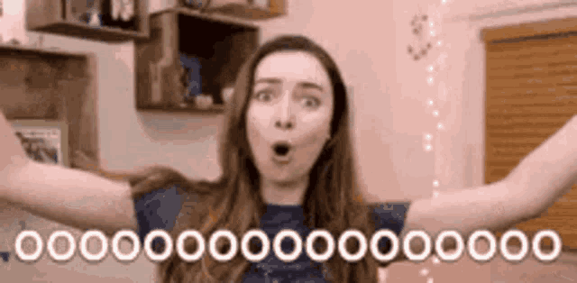 a woman with a surprised look on her face is holding her arms out in the air .