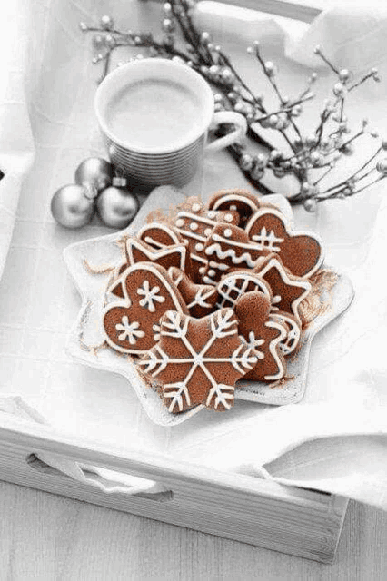 a black and white photo of gingerbread cookies and a cup of coffee .
