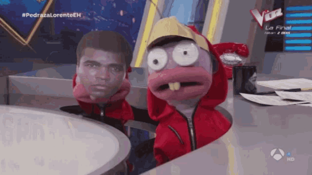 a cartoon character in a red jacket is on a television show called the voice