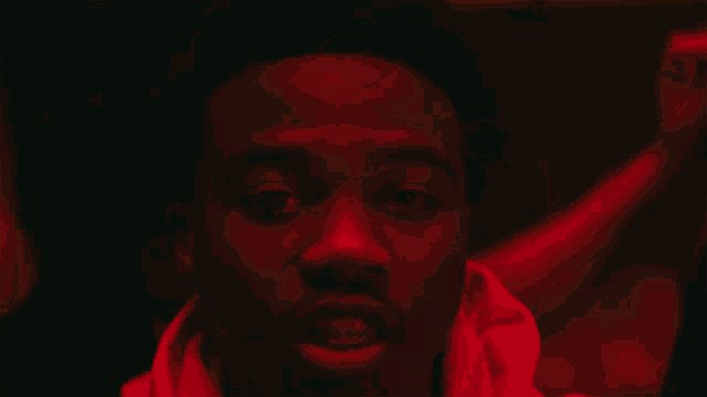 a close up of a man 's face with a red background