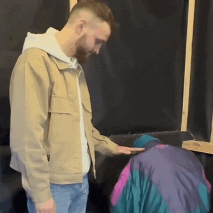 a man in a tan jacket is standing next to a woman in a purple jacket
