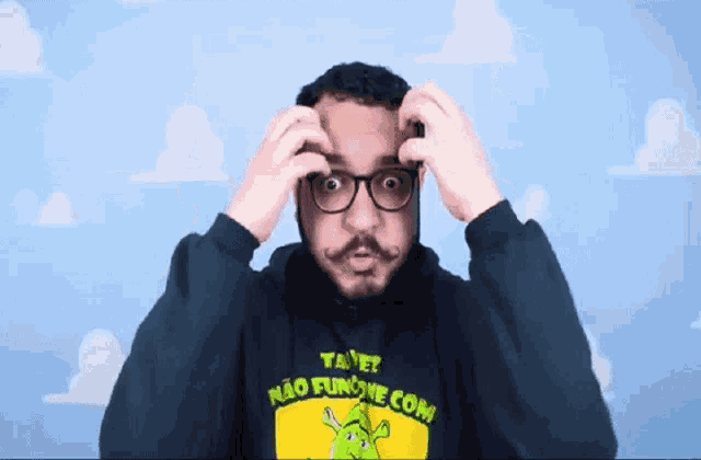 a man wearing glasses and a hoodie that says ta e