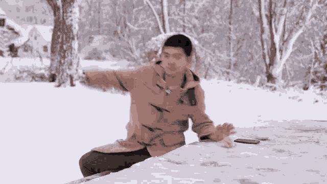 a man in a brown coat is sitting on a snowy table