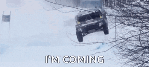 a red bull racing car is driving through the snow .