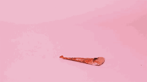a man with a mustache is looking at a slice of pizza on a pink surface .