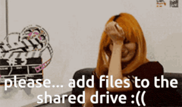 a woman sitting in front of a white board with the words " please add files to the shared drive " written on it