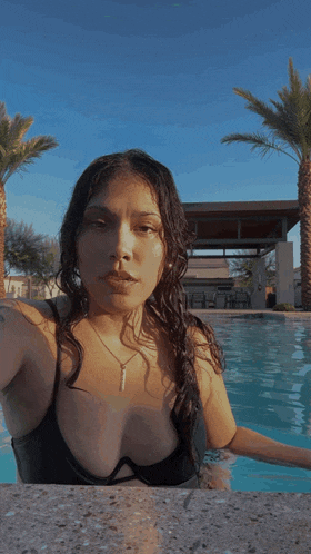 a woman in a bikini is taking a selfie in a swimming pool