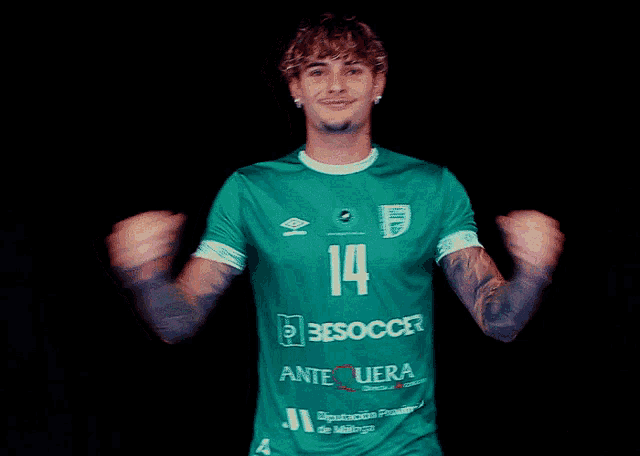 a man wearing a green besoccer shirt with the number 14 on it