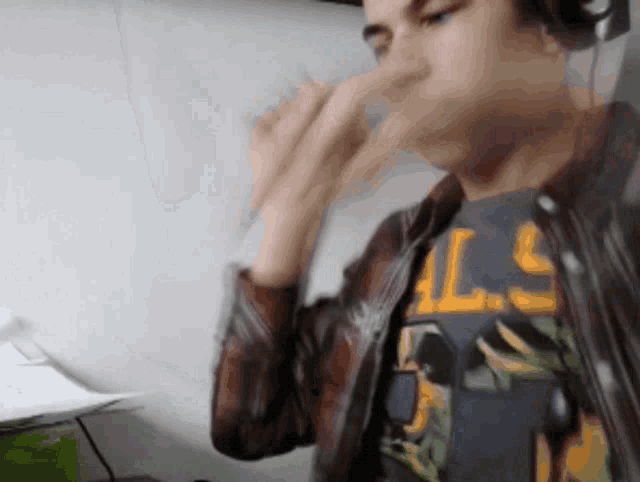 a man wearing headphones and a shirt that says als