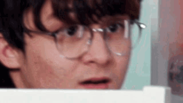 a close up of a man wearing glasses making a funny face .
