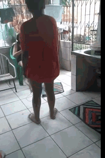 a woman in a red shirt is standing in a room