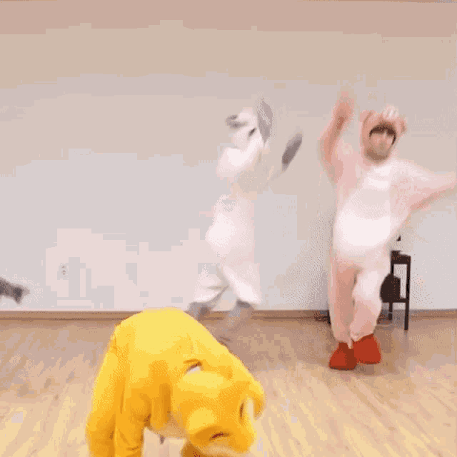 a group of people dressed in costumes are dancing in a room .