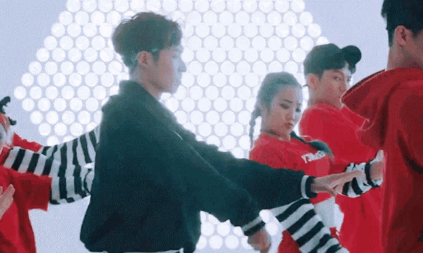 a group of young men and women are dancing together in a room .