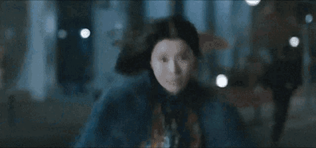 a woman wearing a fur coat is running down a street at night .