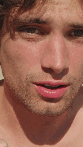 a close up of a man 's face with a beard